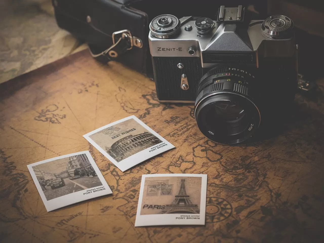 Old map, camera, and photos showing world travel.
